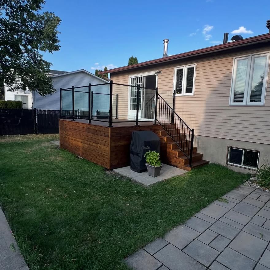 Terrasse en bois avec garde-corps en aluminium noir et patio de pavés